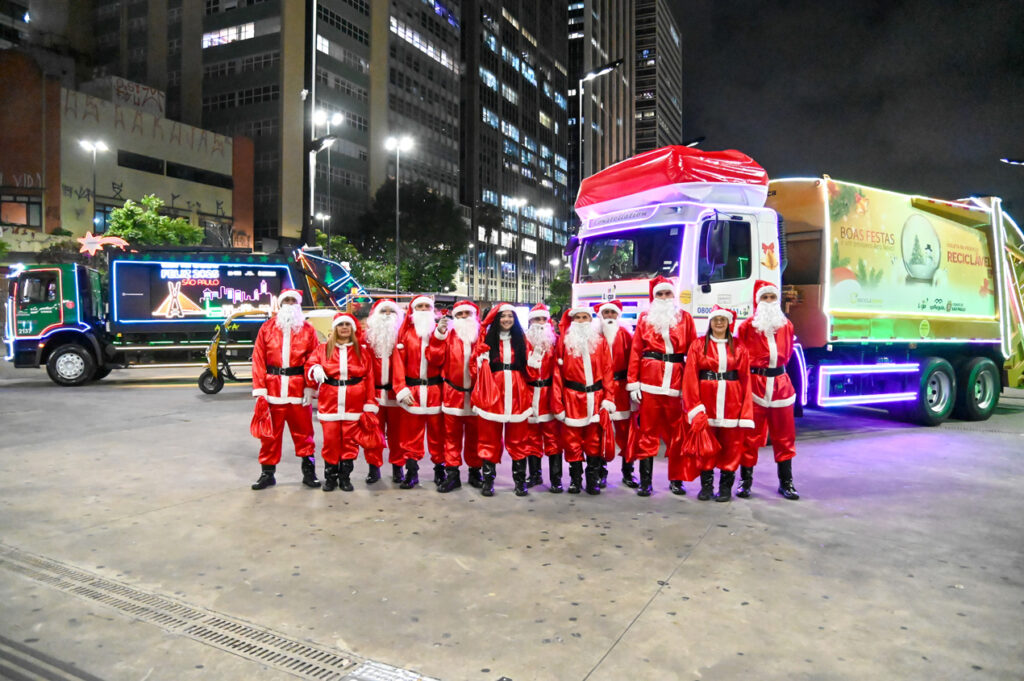 Equipe de noeis Loga na frente dos 2 caminhões de natal