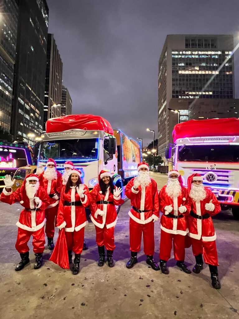 Equipe de noeis Loga na frente dos 2 caminhões de natal